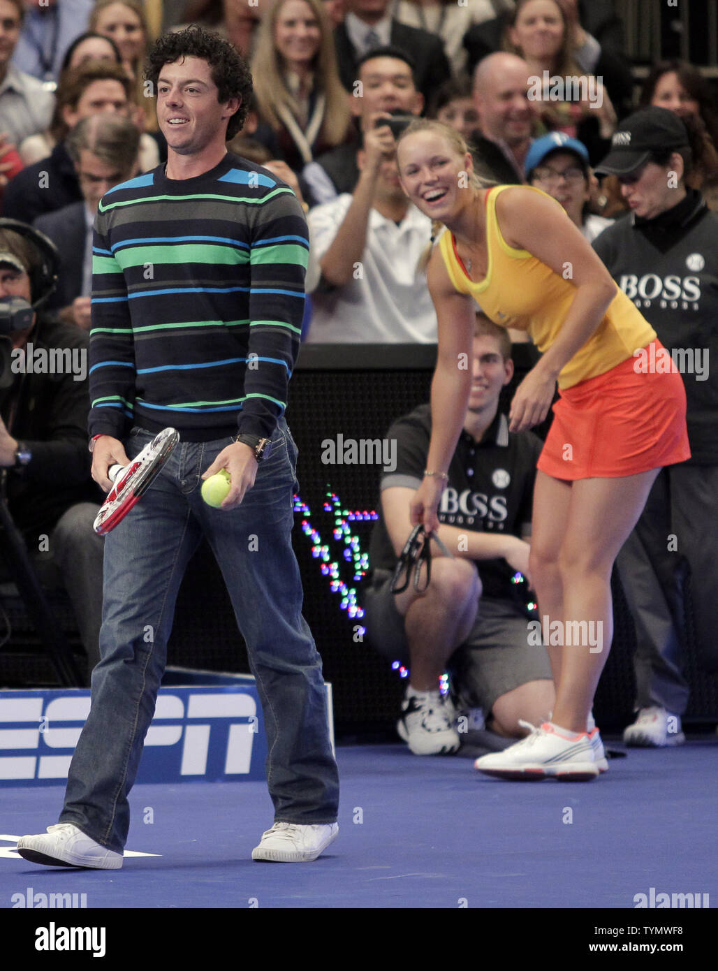Caroline Wozniacki watches boyfriend and PGA Professional Rory McIlroy walk  on the tennis court in her match against Maria Sharapova at the BNP Paribas  Showdown at Madison Square Garden in New York