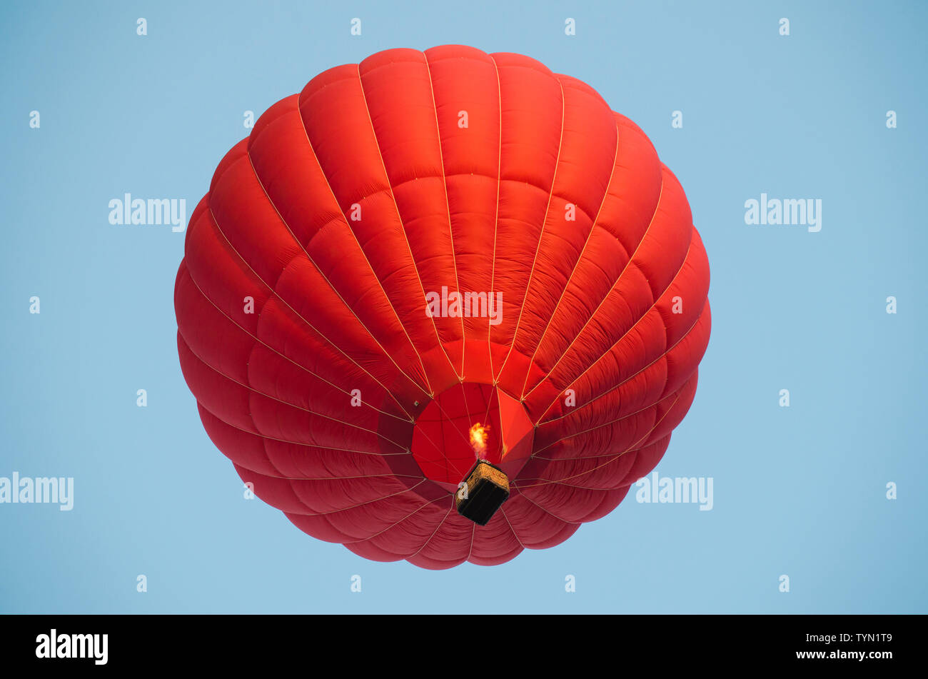 Red hot air balloon in a clear blue sky Stock Photo - Alamy