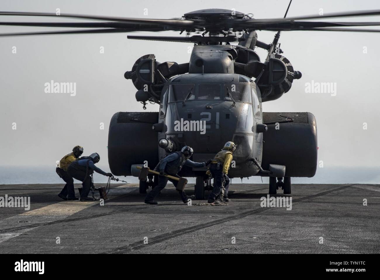 GULF (Nov. 17, 2016) Sailors prepare to chock and chain down an MH-53E Sea Dragon helicopter assigned to the Blackhawks of Helicopter Mine Countermeasures Squadron (HM) 15 to the flight deck of the aircraft carrier USS Dwight D. Eisenhower (CVN 69) (Ike). Ike and its carrier strike group are deployed in support of Operation Inherent Resolve, maritime security operations and theater security cooperation efforts in the U.S. 5th Fleet area of operations. Stock Photo