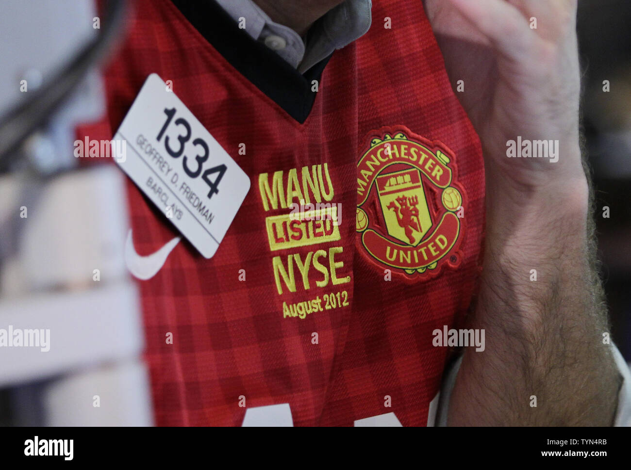 Traders wear the Manchester United Jersey at the New York Stock Exchange on  the day when Manchester United Lists its Initial Public Offering at the NYSE  on Wall Street In New York