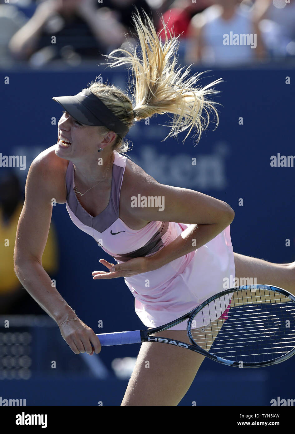 Maria Sharapova of Russia serves in her match against Mallory Burdette