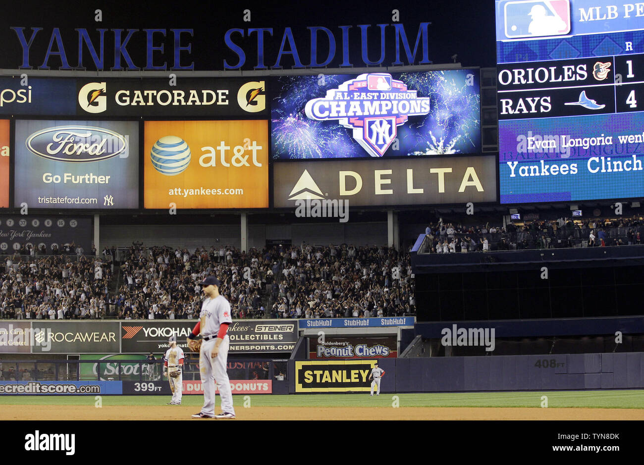 New York Yankee fans react when the Baltimore Orioles score is posted on  the big screen revealing that the Yankees win the MLB American League East  Division in the seventh inning against