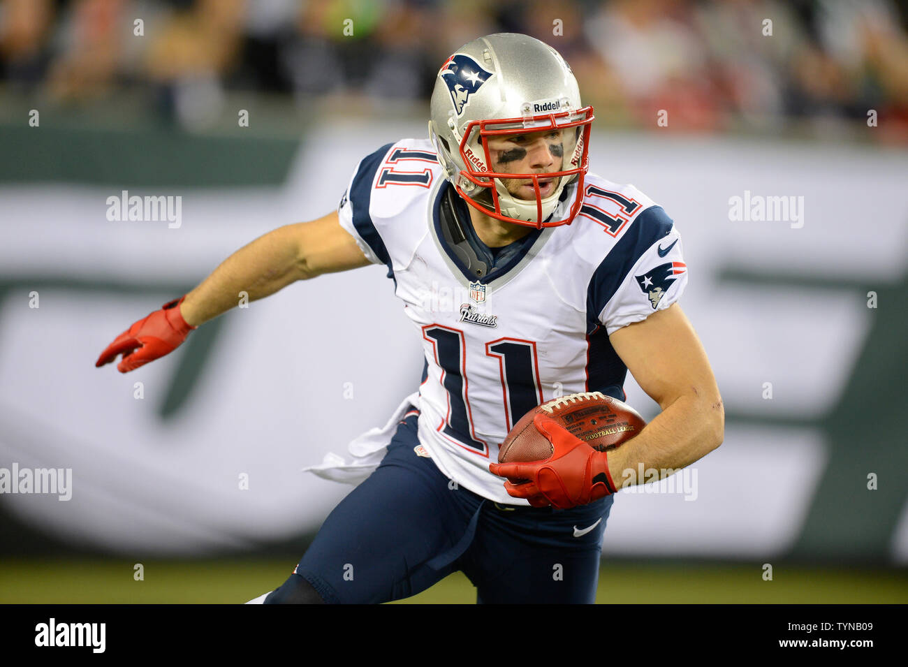 New England Patriots wide receiver Julian Edelman (11) carries back a punt  return for a 30 yard gain in the first quarter against the New York Jets in  week 12 of the