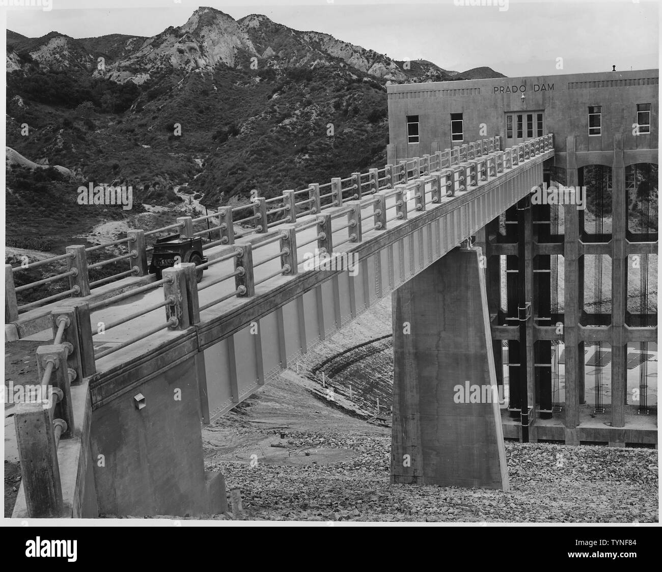 Upstream view from the top of the dam showing the service bridge and outlet control tower completed. Location: Prado dam across the Santa Ana River. Funds: Regular Funds and money contributed by Orange County. Work prosecuted under Contract No. 509-Eng.-749. Stock Photo