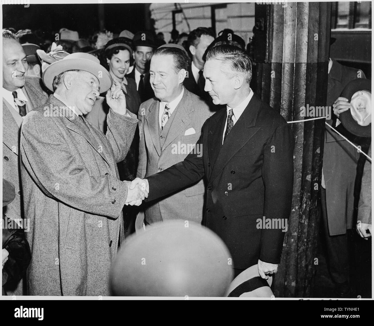Vice President-elect Alben W. Barkley shakes hands with James V. Forrestal, with others looking on. Stock Photo