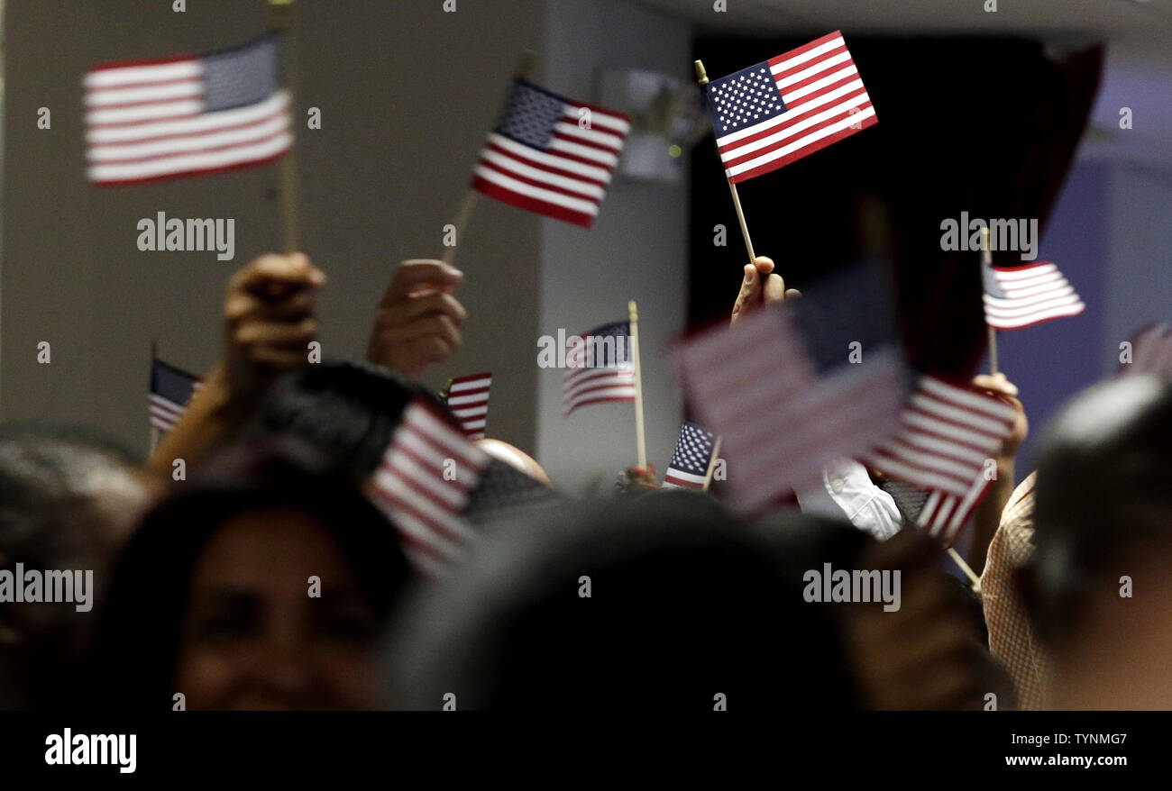 New Citizens of the United States wave American Flags when U.S. Citizenship and Immigration Services officials hold a naturalization ceremony for 150 immigrants in New York City on July 2, 2013. U.S. Citizenship and Immigration Services (USCIS) conducted three naturalization ceremonies for 450 people today in Manhattan 2 days before the July 4th holiday.     UPI/John Angelillo Stock Photo