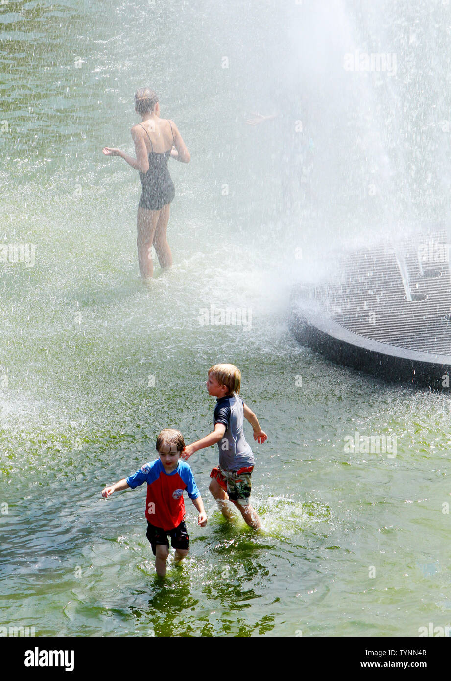 People splash around in the fountain in Washington Square Park as temperatures approach the triple digit mark on July 18, 2013 in New York. People are finding ways to stay cool as heat advisories are in effect while an oppressive heat wave continues across the area.     UPI/Monika Graff Stock Photo