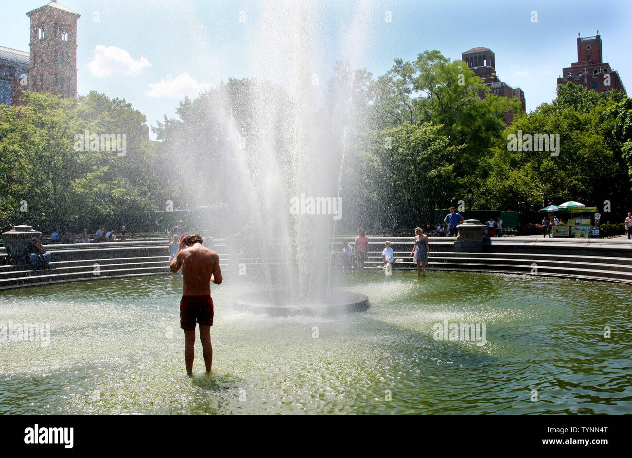 A man cools off in the fountain in Washington Square Park as temperatures approach the triple digit mark on July 18, 2013 in New York. People are finding ways to stay cool as heat advisories are in effect while an oppressive heat wave continues across the area.     UPI/Monika Graff Stock Photo