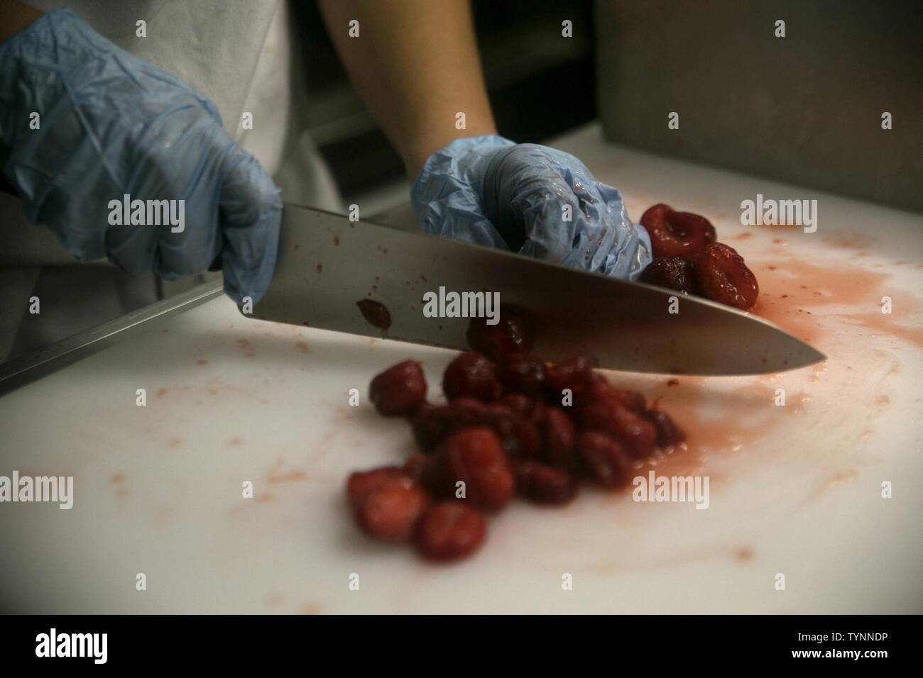 Staff Sgt. Rosa Lozoyabuite dices strawberries for the Maj. Gen. William Pendleton Thompson Hill Award competitions on Camp Lejeune, Nov. 18, 2016. Three units from the East Coast to include, Marine Logistics Group, Marine Headquarters Group, and the 2nd Marine Air Wing competed to see who is the most proficient and efficient in a food service field environment. Lozoyabuite is the Assistance Mess Chief for 2nd MHG. Stock Photo