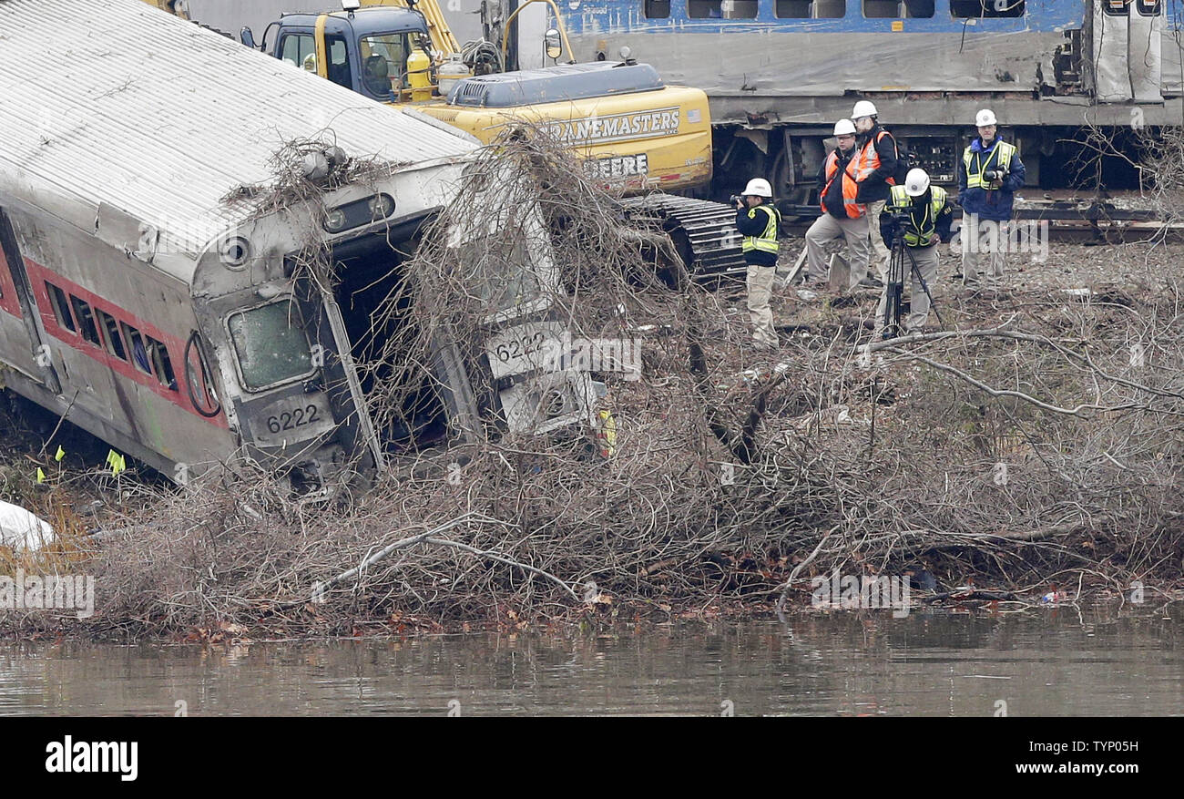 Crews, Investigators and Police prepare to lift and remove sections of a  Metro-North Train after it derailed on route to Grand Central Station the  day before in New York City on December, image size:1300x877