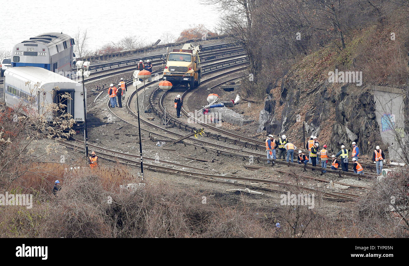 Crews, Investigators and Police prepare to lift and remove sections of a  Metro-North Train after it derailed on route to Grand Central Station the  day before in New York City on December, image size:1300x845