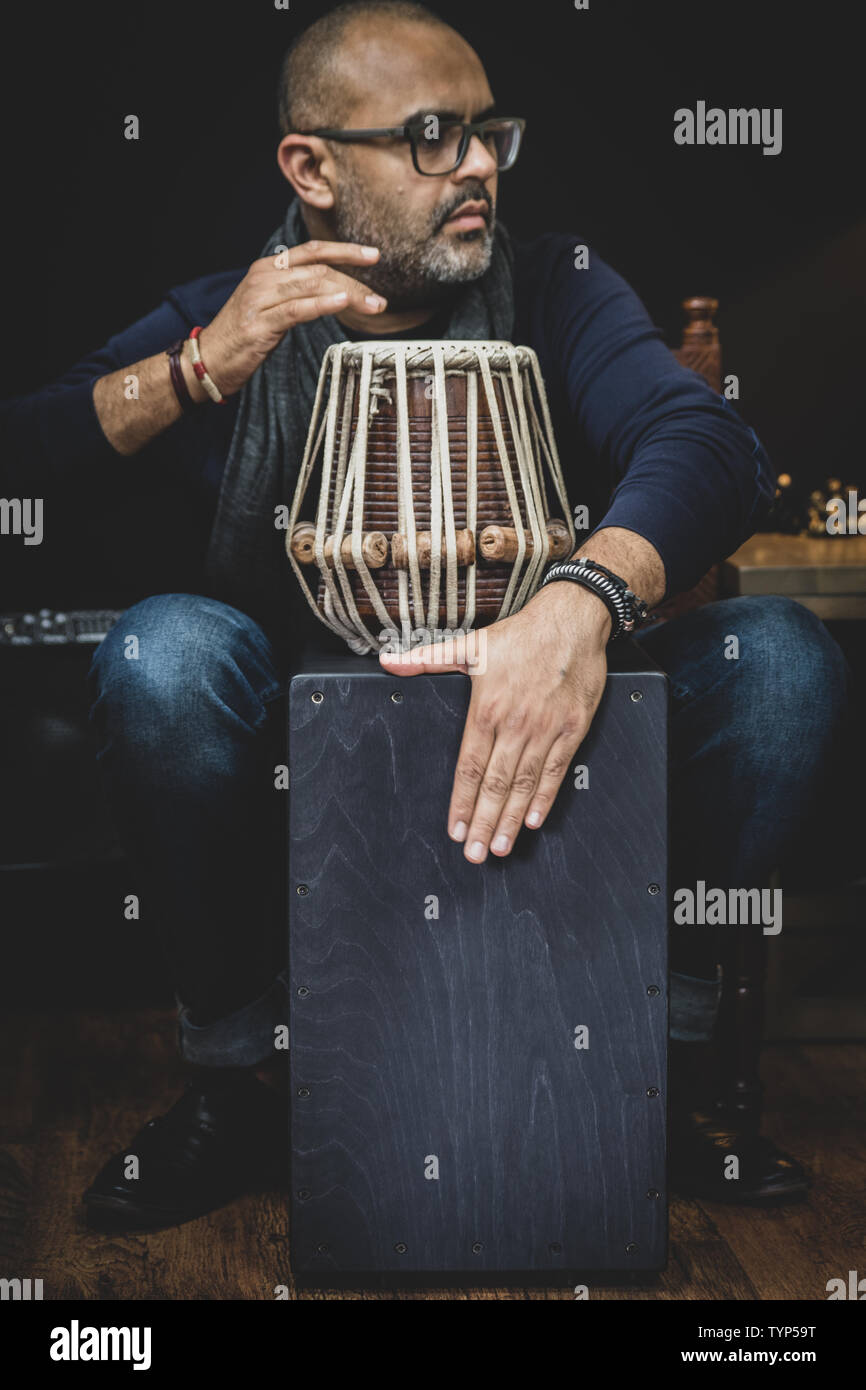 Man's hands playing the percussion instrument Cajon. It is a percussion