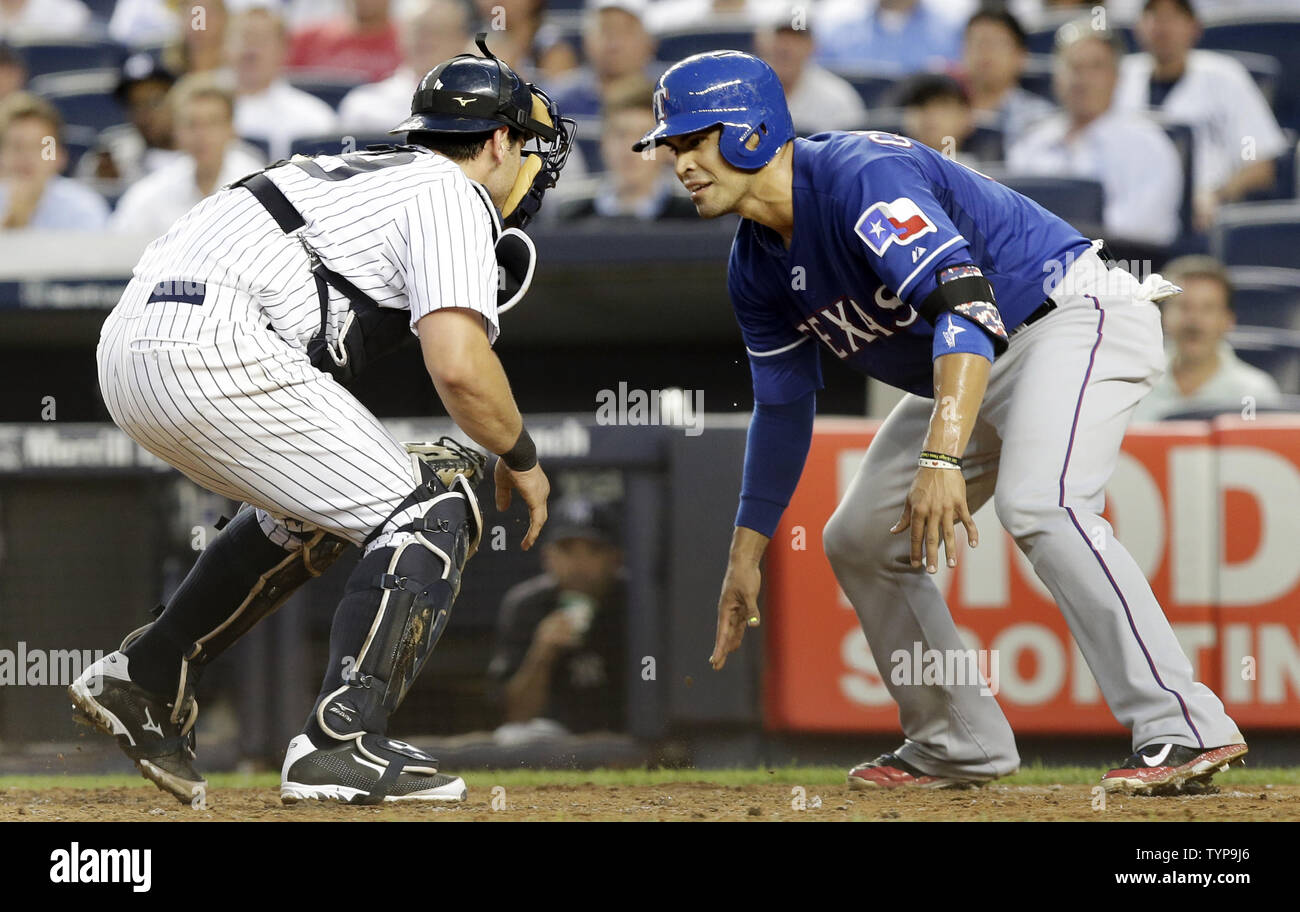 Texas Rangers Robinson Chirinos tries to avoid being tagged and is eventually tagged out at home plate by New York Yankees Francisco Cervelli in the fifth inning at Yankee Stadium in New York City on on July 22, 2014.     UPI/John Angelillo Stock Photo