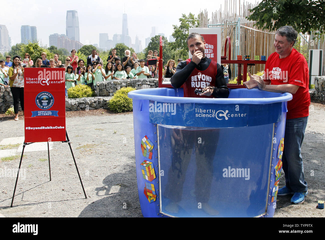 North American Speed Cube Champion Anthony Brooks smiles as he emerges from a water tank after he breaks the Guinness Record for most Rubik's Cube puzzles solved underwater in one breath at National Rubik's Cube Championship at Liberty Science Center in Jersey City, NJ on August 1, 2014. Brooks set a new record solving 5 cubes in 1:18 beating the old record of record 4 cubes solved in 1:30. UPI/John Angelillo Stock Photo