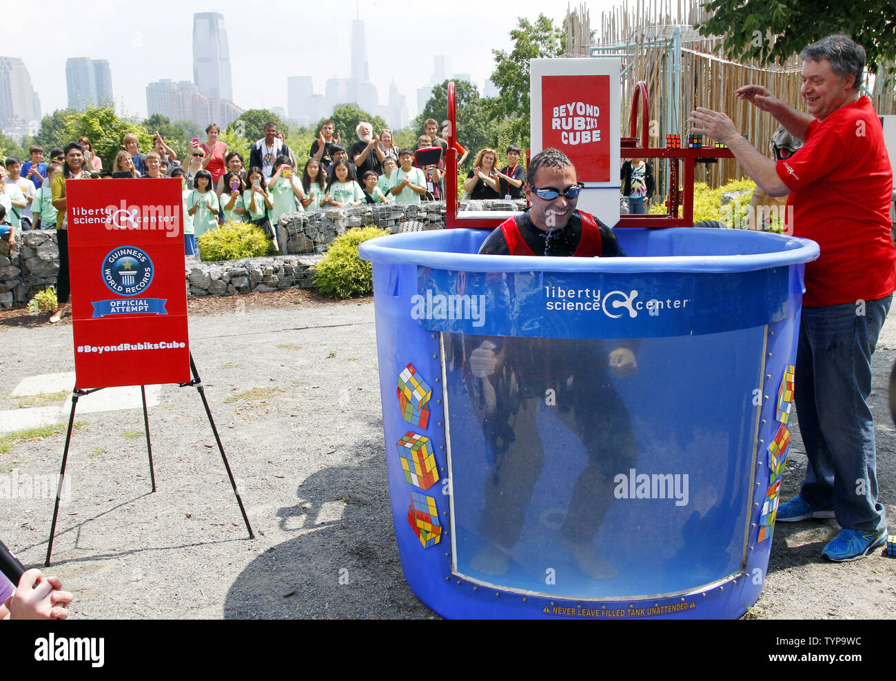 North American Speed Cube Champion Anthony Brooks smiles as he emerges from a water tank after he breaks the Guinness Record for most Rubik's Cube puzzles solved underwater in one breath at National Rubik's Cube Championship at Liberty Science Center in Jersey City, NJ on August 1, 2014. Brooks set a new record solving 5 cubes in 1:18 beating the old record of record 4 cubes solved in 1:30.  UPI/John Angelillo Stock Photo