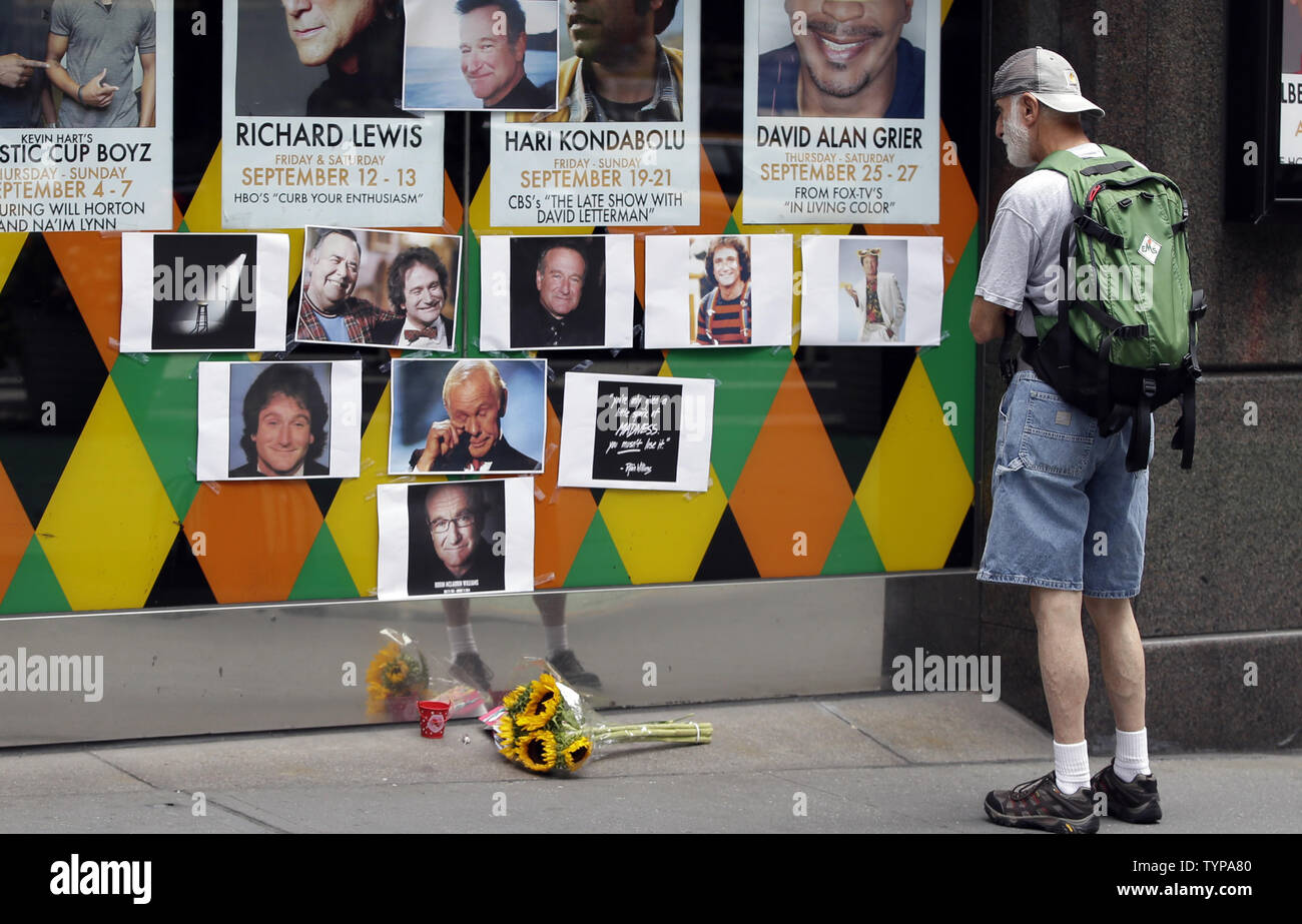 A man stops to look at a tribute and memorial to the late Robin Williams at the entrance to Carolines on Broadway comedy club in New York City on August 12, 2014. Robin Williams committed suicide by hanging himself with a belt, the coroner said Tuesday in a press conference detailing the preliminary findings surrounding the actor and comedian's death.          UPI/John Angelillo Stock Photo