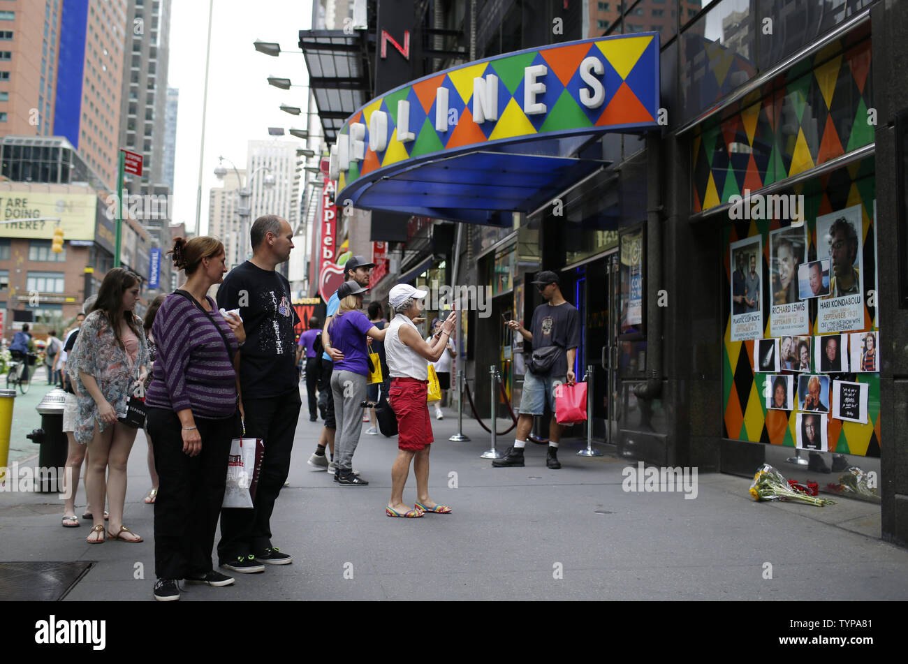 People stop to look at a tribute and memorial of the late Robin Williams at the entrance to Carolines on Broadway comedy club in New York City on August 12, 2014. Robin Williams committed suicide by hanging himself with a belt, the coroner said Tuesday in a press conference detailing the preliminary findings surrounding the actor and comedian's death.          UPI/John Angelillo Stock Photo