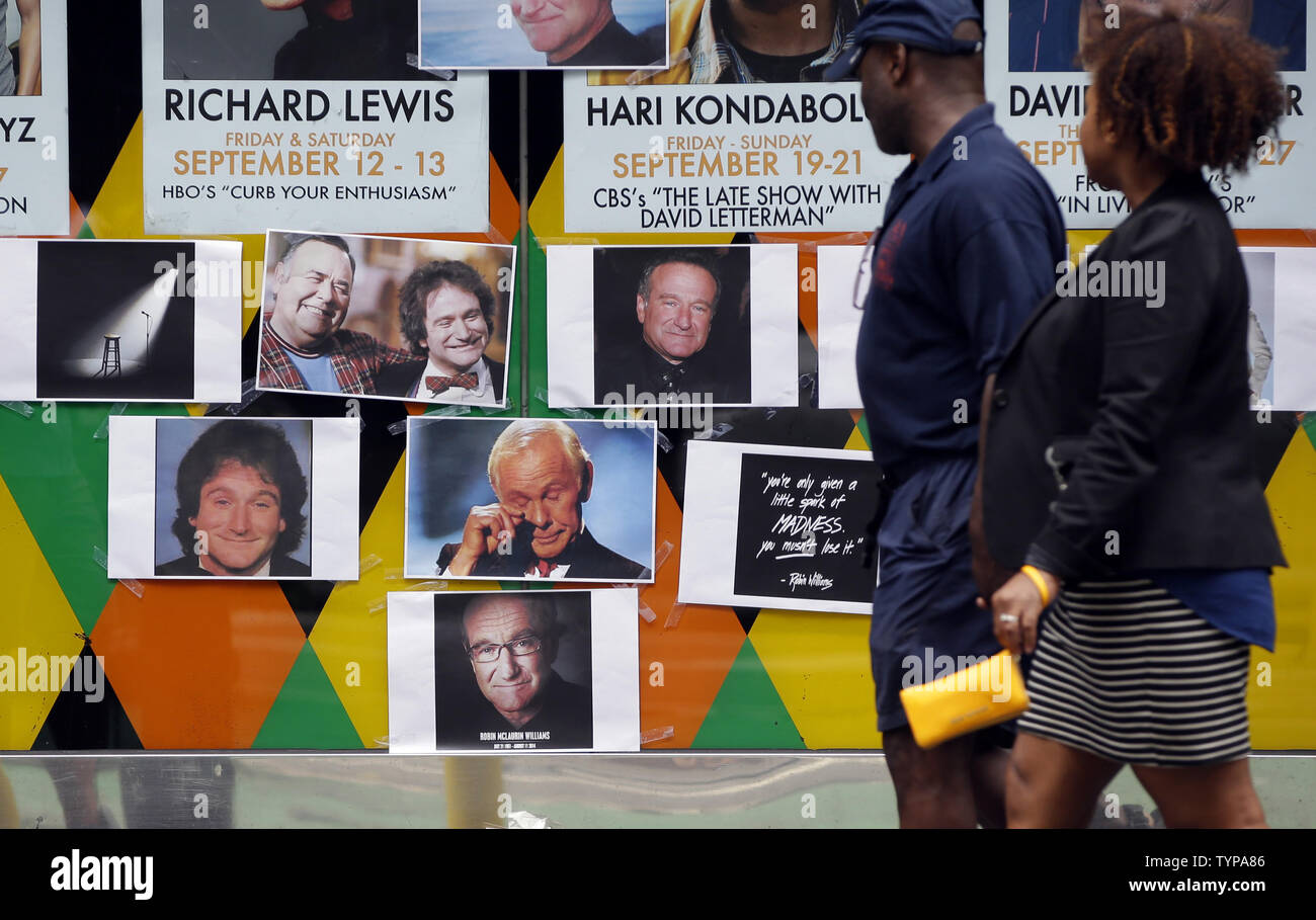 People walk by a tribute and memorial to the late Robin Williams at the entrance to Carolines on Broadway comedy club in New York City on August 12, 2014. Robin Williams committed suicide by hanging himself with a belt, the coroner said Tuesday in a press conference detailing the preliminary findings surrounding the actor and comedian's death.          UPI/John Angelillo Stock Photo
