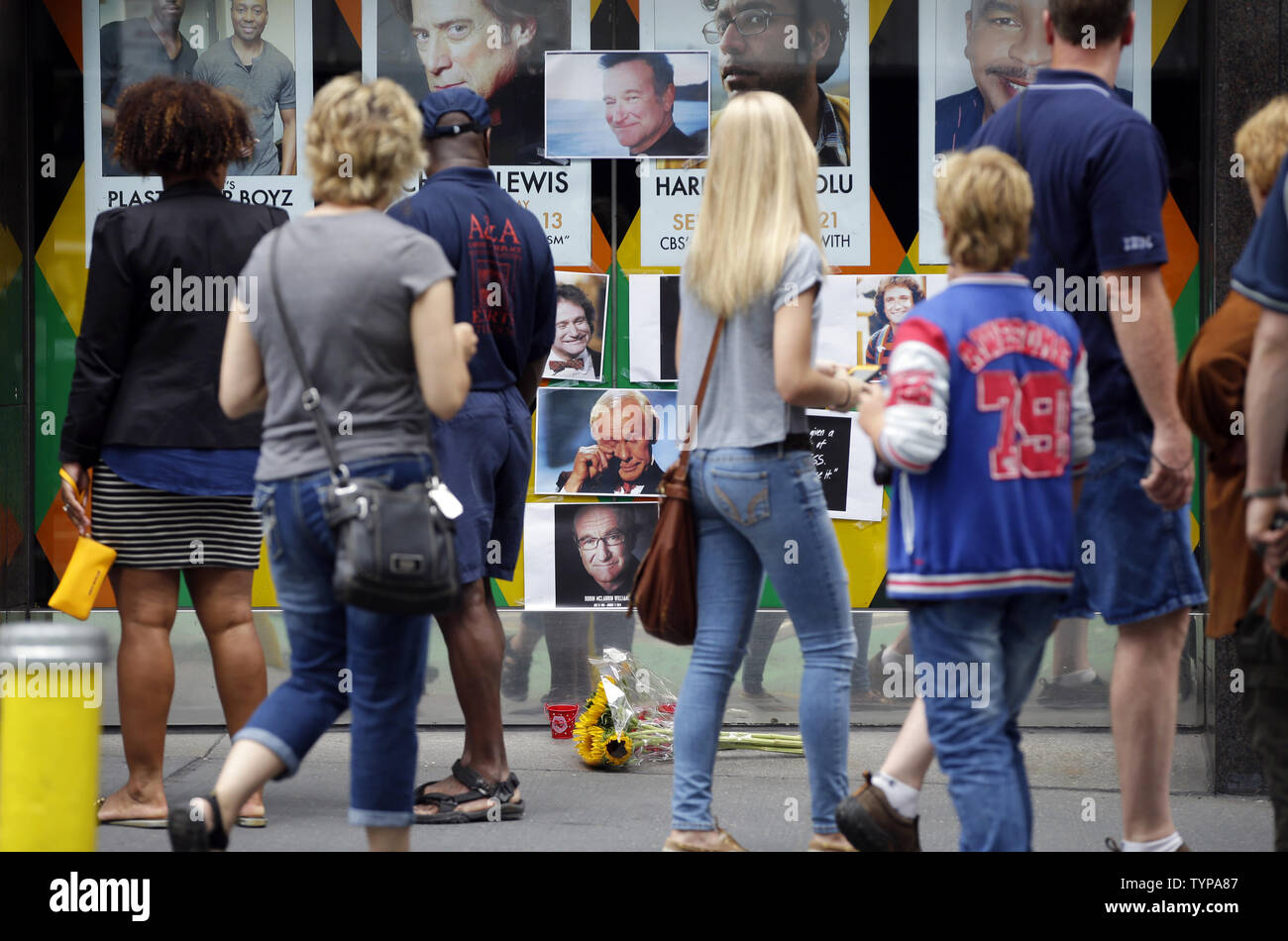 People stop to look at a tribute and memorial to the late Robin Williams at the entrance to Carolines on Broadway comedy club in New York City on August 12, 2014. Robin Williams committed suicide by hanging himself with a belt, the coroner said Tuesday in a press conference detailing the preliminary findings surrounding the actor and comedian's death.          UPI/John Angelillo Stock Photo