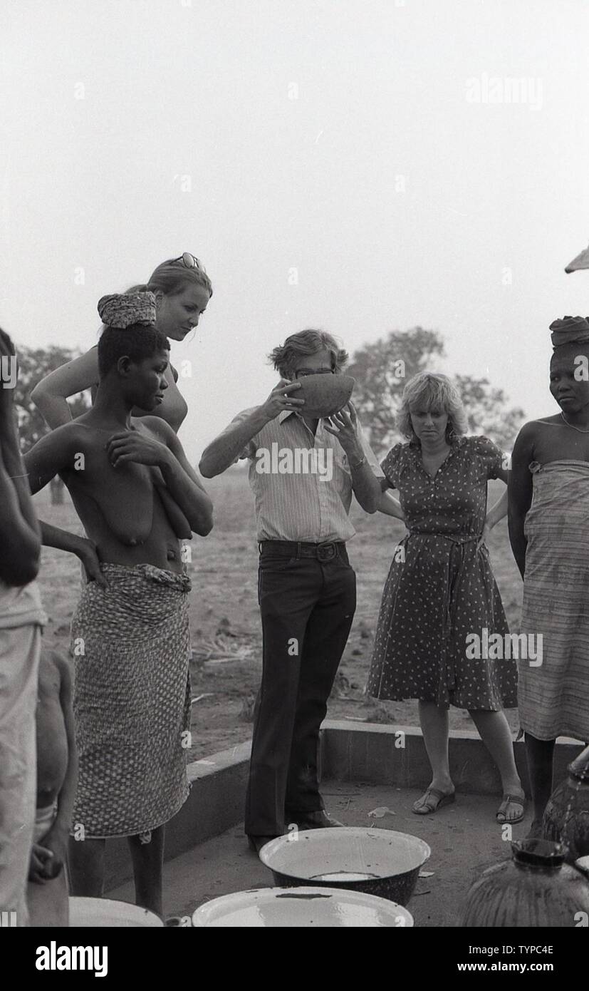 MAN DRINKING WATER WHILE OTHERS STAND AROUND Stock Photo Alamy