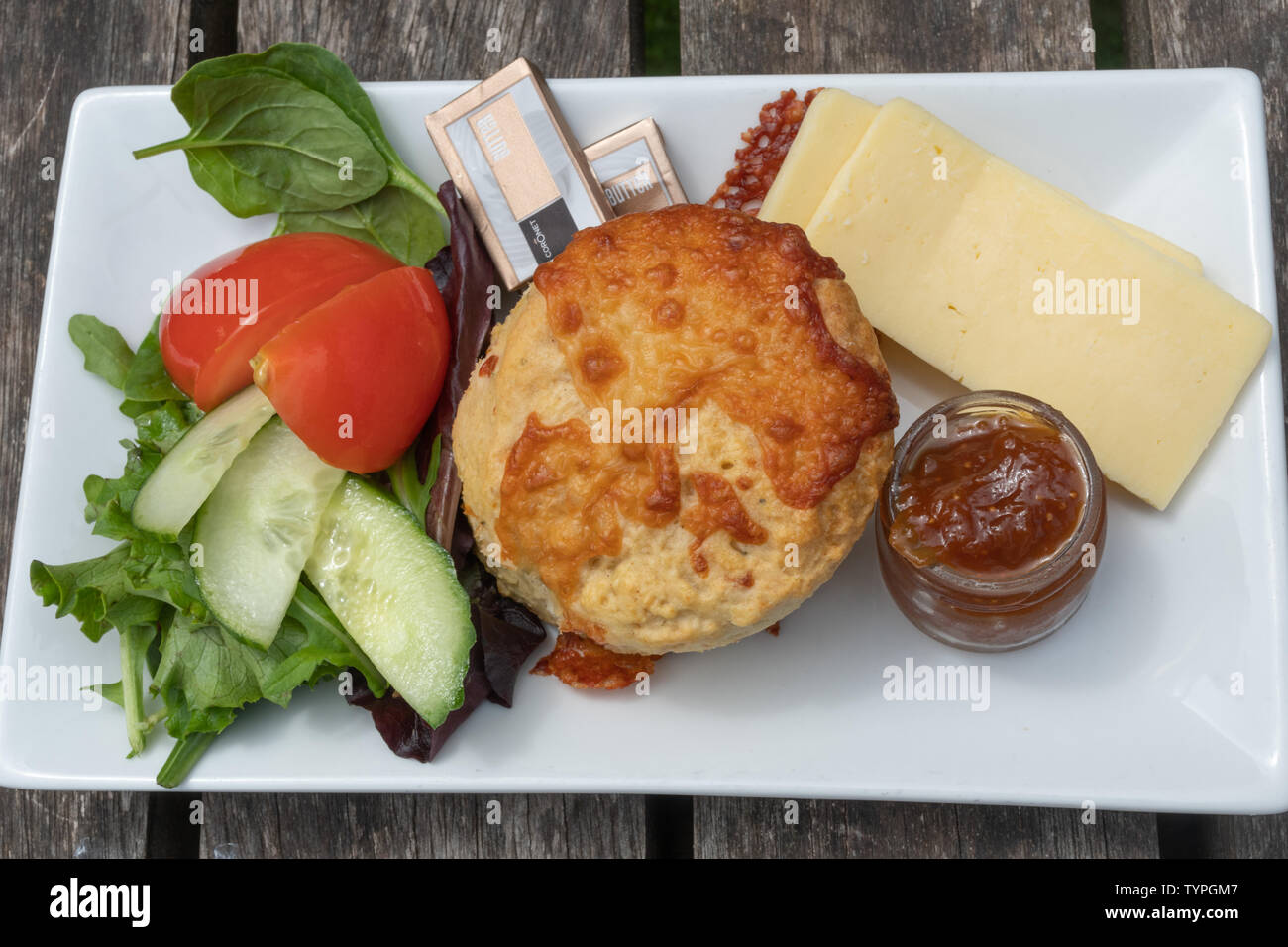 A savoury tea with cheese scone, cheese, butter, chutney and salad, England, UK Stock Photo
