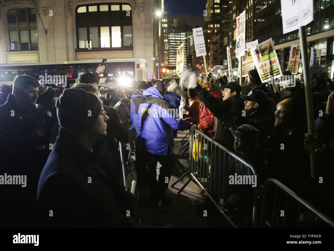 Two separate protests, both for and against police, are kept separate by the NYPD outside of City Hall in lower Manhattan over 2 weeks after a decision by a grand jury not to indict an NYPD officer involved in the apparent chokehold death of Eric Garner in New York City on December 19, 2014. Demonstrators gathered at City Hall in support of the NYPD Friday evening, but they were met right away with a rival demonstration by critics of police policies. Garner, a 43 year old father of six, died in July after police officers attempted to arrest him for allegedly selling loose, untaxed cigarettes i Stock Photo