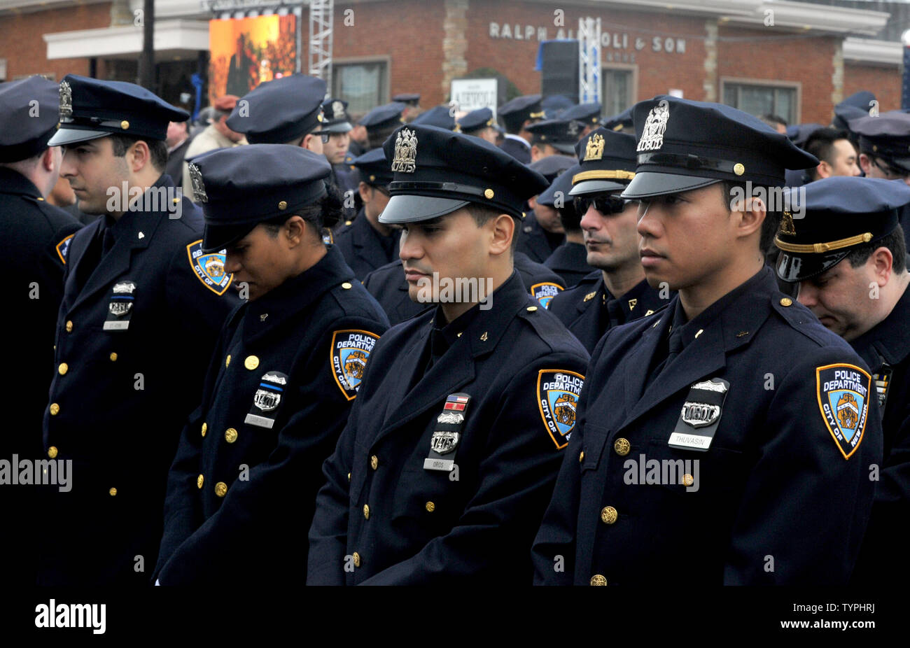 NYPD Police officers stand outside and bow their heads at the funeral ...