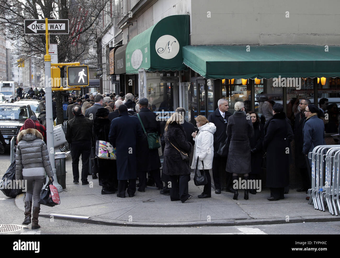 Mourners wait on a line that goes around the block at the wake for