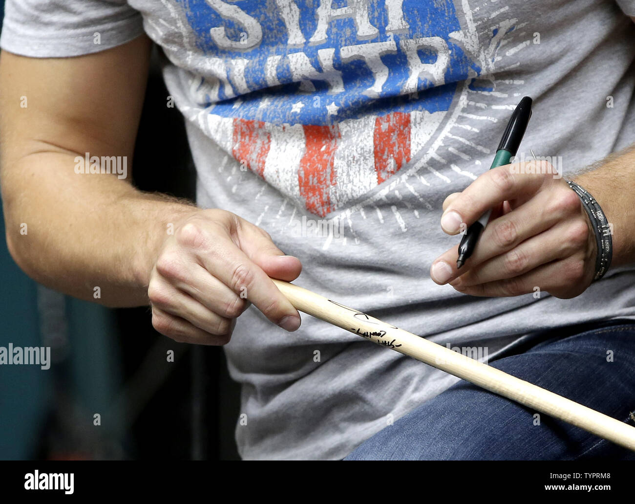 Dustin Lynch signs an autograph on a drumstick after he performs on Fox and Friends All American
