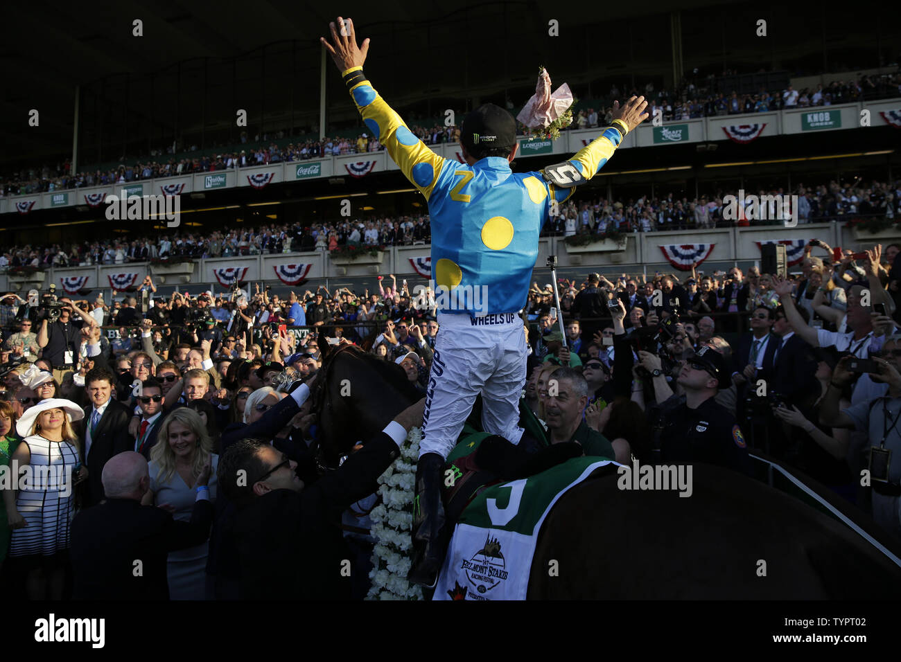 Jockey Victor Espinosa throws a bouquet of flowers in the winners