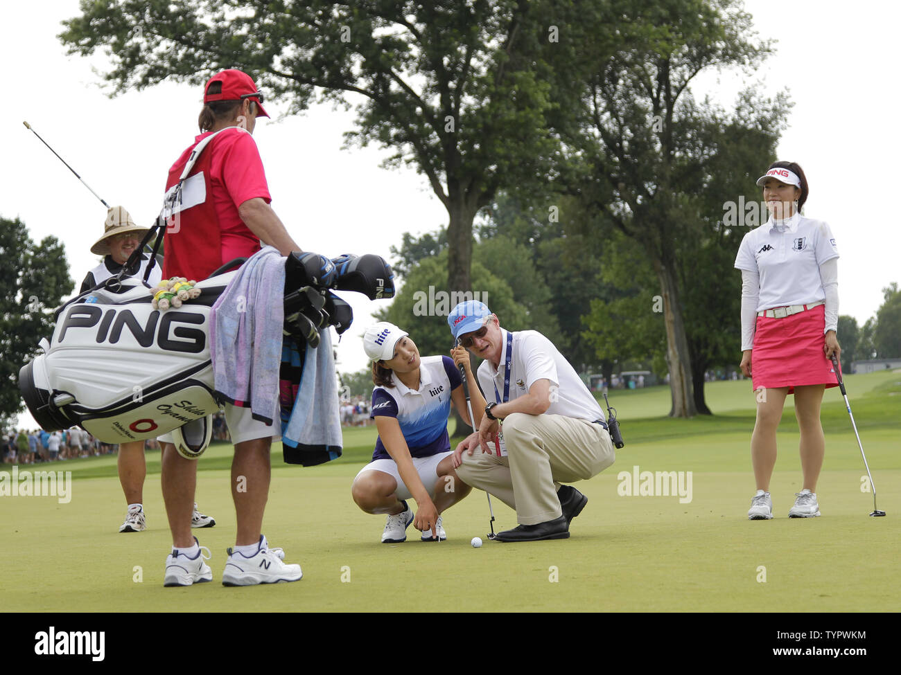 Shiho Oyama of Japan watches In Gee Chun of Korea discuss where to place the ball on the first hole green with an official in the final round of the LPGA U.S. Women's Open Championship at Lancaster Country Club in Lancaster, PA on July 12, 2015.       Photo by John Angelillo/UPI Stock Photo