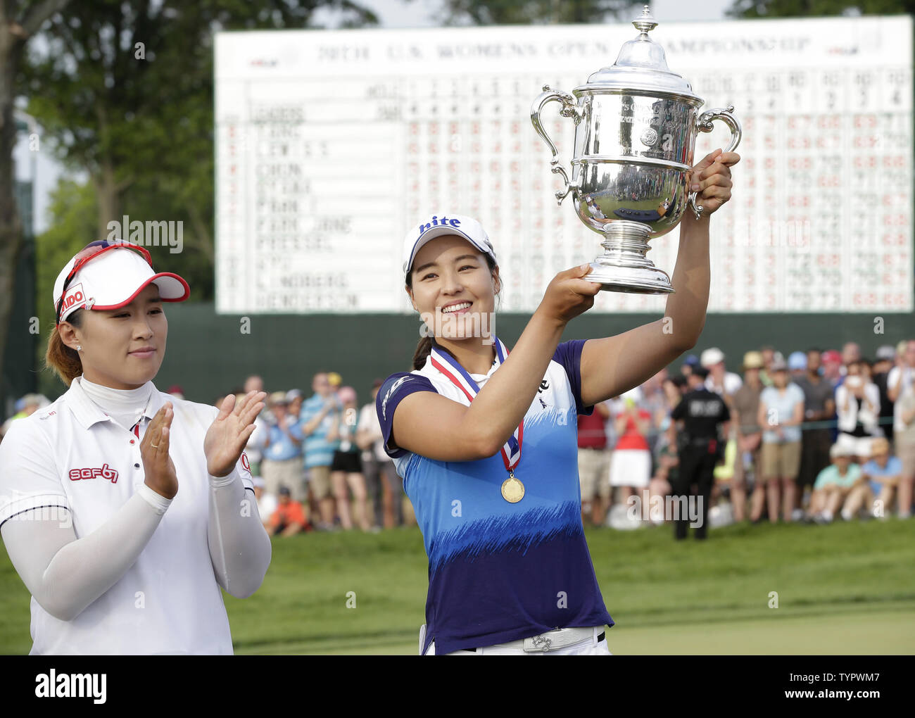 In Gee Chun of Korea holds up the championship trophy standing next to runner up Amy Yang of Korea on the 18th green in the final round of the LPGA U.S. Women's Open Championship at Lancaster Country Club in Lancaster, PA on July 12, 2015. Chun wins the U.S. Women's Open and her first LPGA major championship with a score of 8 under par.     Photo by John Angelillo/UPI Stock Photo