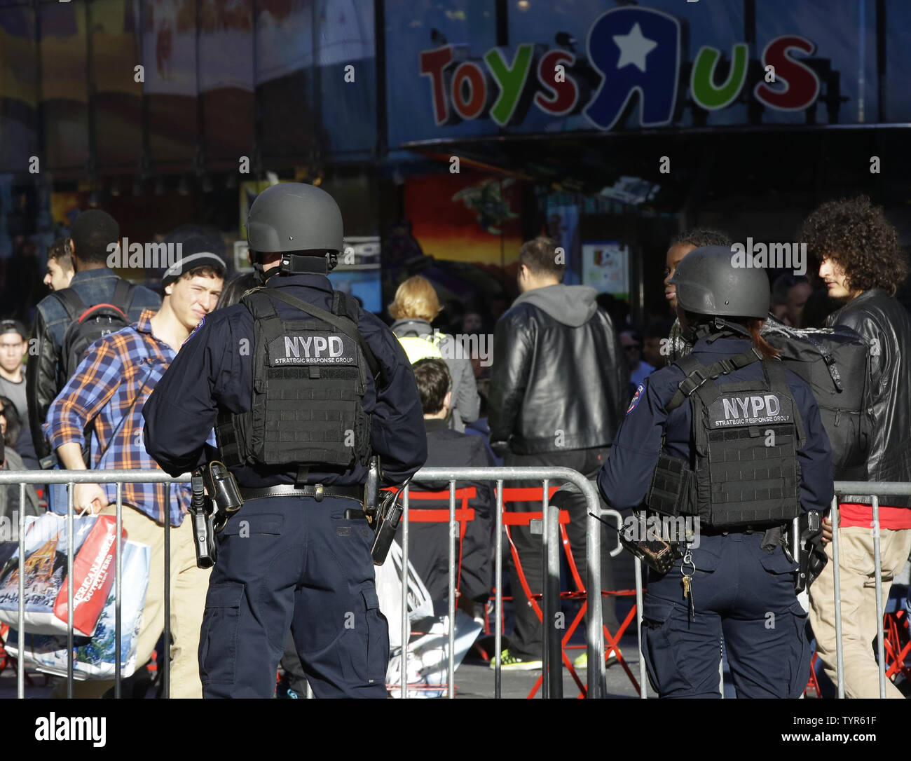 Shoppers walk walk through Times Square where two NYPD Strategic Response  Group men stand outside on surveillance on Black Friday in New York City on  November 27, 2015. For nearly a decade,