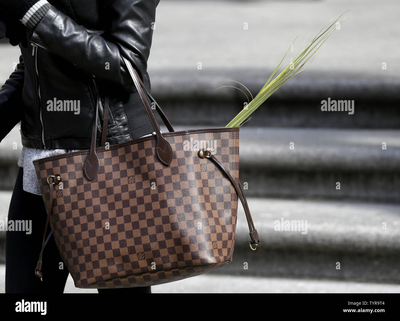 A woman carries palms in her Louis Vuitton bag outside of St. Patrick's  Cathedral on Palm Sunday on March 20, 2016 in New York City. Palm Sunday is  the final Sunday of