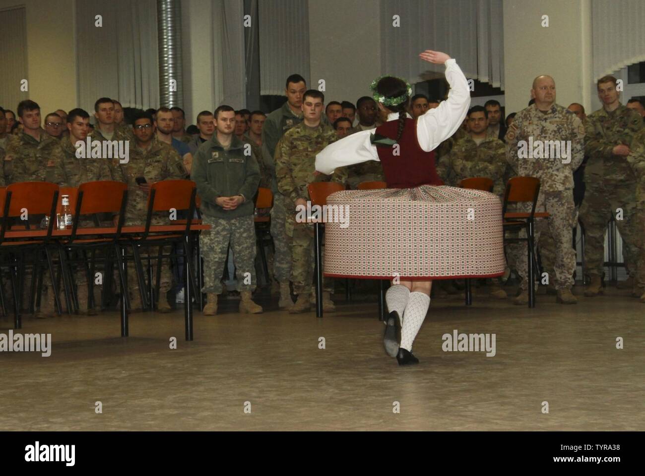 ADAZI, Latvia – Traditional Latvian folk dancers perform for U.S. Paratroopers of 2nd Battalion, 503rd Infantry Regiment, 173rd Airborne Brigade, and the Latvian Land Forces Infantry Brigade, before sharing Thanksgiving dinner at Camp Adazi, Latvia, Nov. 22, 2016. A culinary team comprised of Paratroopers from Hound Company, 2nd Bn., 503rd Inf. Regt., and 240th Quartermaster Supply Company, 18th Combat Sustainment Support Battalion, 16th Sustainment Brigade, 21st Theater Sustainment Command, prepared Thanksgiving dinner for over 600 hungry soldiers. The “Sky Soldiers” of 2nd Bn., 503rd Inf. Re Stock Photo