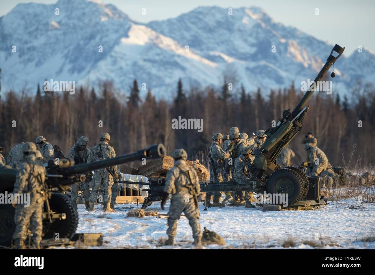 Paratroopers assigned to A Battery, 2nd Battalion, 377th Parachute Field Artillery Regiment, 4th Infantry Brigade Combat Team (Airborne), 25th Infantry Division, U.S. Army Alaska, prepare to fire 105 mm howitzers during airborne and live fire training at Joint Base Elmendorf-Richardson, Alaska, Nov. 22, 2016. Following a heavy equipment drop and parachute assault, the paratroopers honed their skills by setting up and firing a 105 mm howitzer. The Soldiers of 4/25 IBCT belong to the only American airborne brigade in the Pacific and are trained to execute airborne maneuvers in extreme cold weath Stock Photo