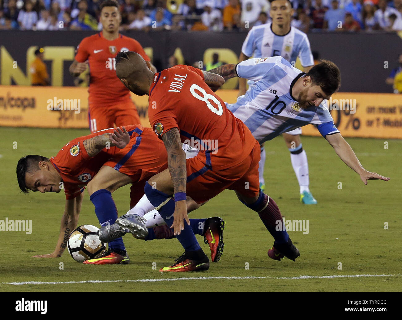 Argentina midfielder Lionel Messi (10) goes down as he gets caught between Chile midfielders Charles Aranguiz and Arturo Vidal (8) in the second half at the Copa America Centenario USA 2016 Finals at MetLife Stadium in East Rutherford, New Jersey on June 26, 2016.      Photo by Ray Stubblebine/UPI Stock Photo