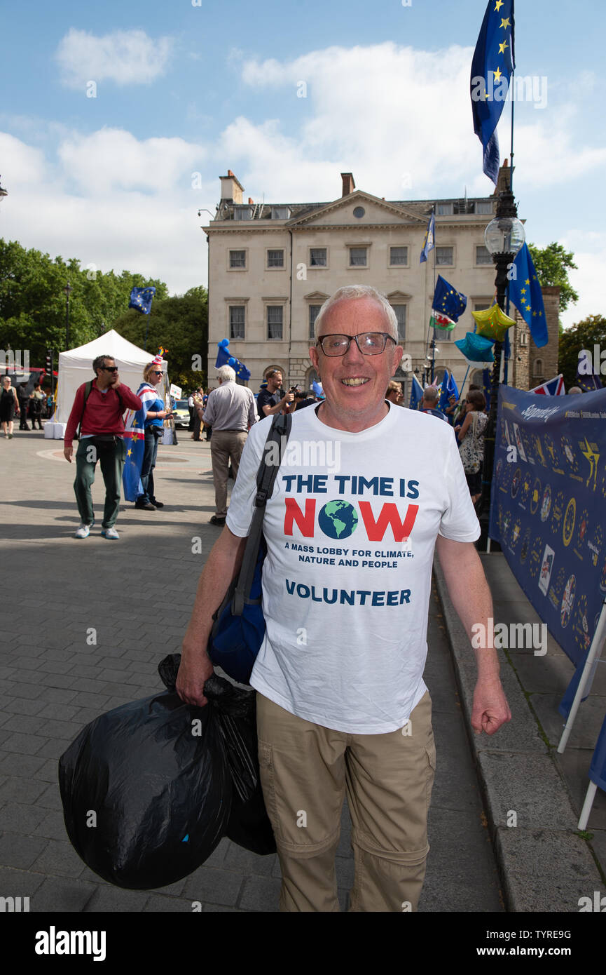 Westminster, London, UK. 26th June, 2019. A volunteer for the Time is Now walks along Millbank, Westminster following the lobby.  The Time is Now was a mass lobby for climate, nature and people held around the streets in Westminster. Credit: Maureen McLean/Alamy Stock Photo