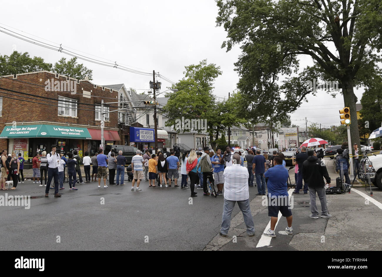 Spectators, Media, FBI investigators and police gather outside First American Fried Chicken after Ahmad Khan Rahami, the man responsible for the New York and New Jersey bombings, was apprehended by police on September 19, 2016 in Elizabeth, New Jersey. Two days before, an explosion from a bomb went off on West 23rd Street in Manhattan around 8:30 p.m. on Saturday, injuring 29 people on West 23rd Street in Manhattan. The man responsible for the explosion in Manhattan on Saturday night and an earlier bombing in New Jersey, Ahmad Khan Rahami, was taken into custody on Monday after he was wounded Stock Photo