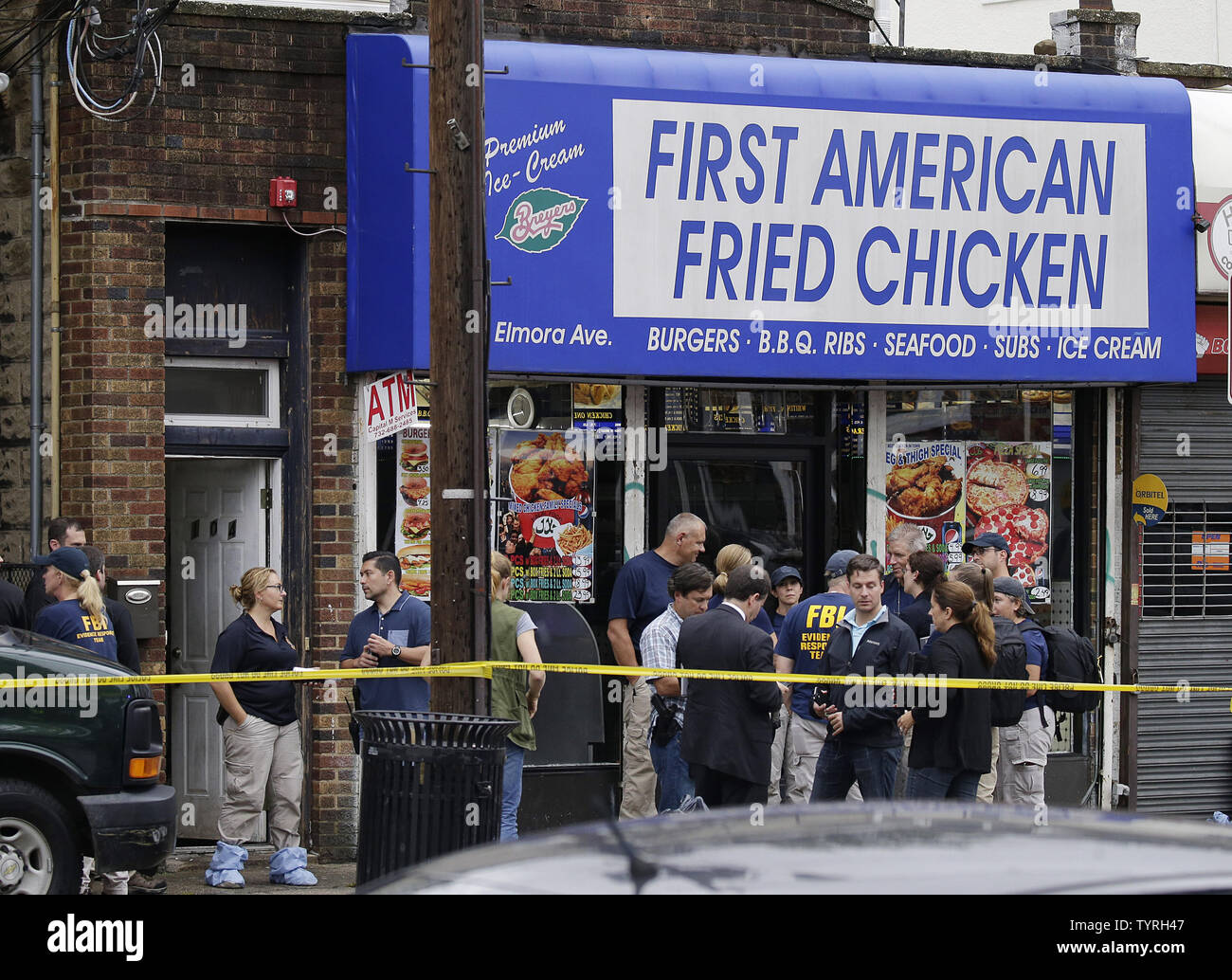 FBI investigators and police gather outside First American Fried Chicken after Ahmad Khan Rahami, the man responsible for the New York and New Jersey bombings, was apprehended by police on September 19, 2016 in Elizabeth, New Jersey. Two days before, an explosion from a bomb went off on West 23rd Street in Manhattan around 8:30 p.m. on Saturday, injuring 29 people on West 23rd Street in Manhattan. The man responsible for the explosion in Manhattan on Saturday night and an earlier bombing in New Jersey, Ahmad Khan Rahami, was taken into custody on Monday after he was wounded in a gunfight with Stock Photo