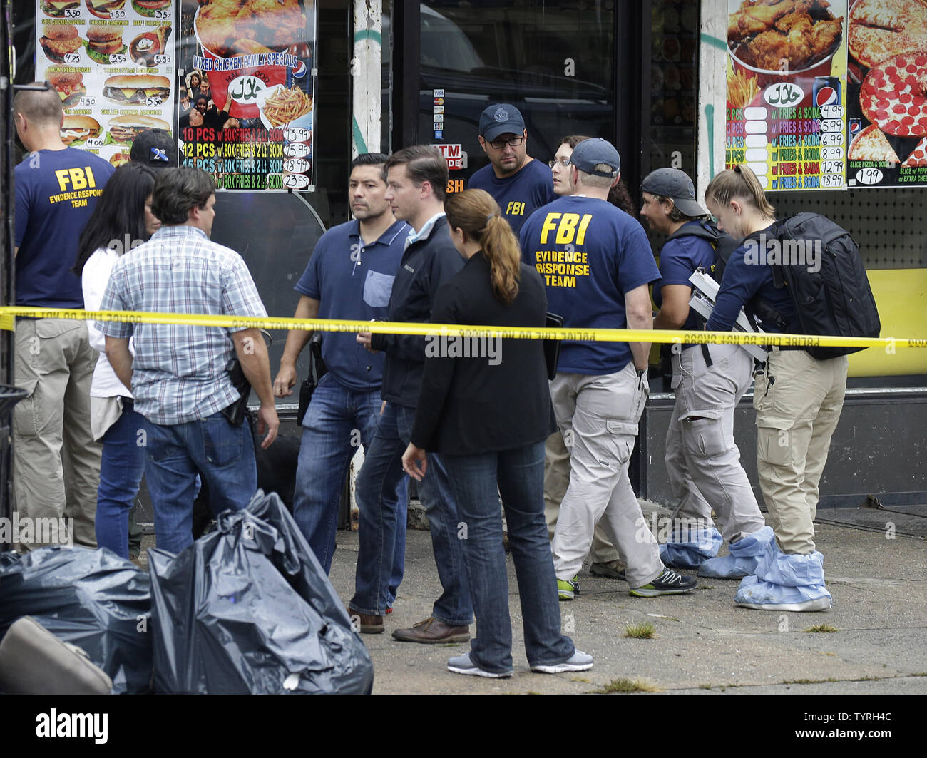 FBI investigators and police gather outside First American Fried Chicken after Ahmad Khan Rahami, the man responsible for the New York and New Jersey bombings, was apprehended by police on September 19, 2016 in Elizabeth, New Jersey. Two days before, an explosion from a bomb went off on West 23rd Street in Manhattan around 8:30 p.m. on Saturday, injuring 29 people on West 23rd Street in Manhattan. The man responsible for the explosion in Manhattan on Saturday night and an earlier bombing in New Jersey, Ahmad Khan Rahami, was taken into custody on Monday after he was wounded in a gunfight with Stock Photo