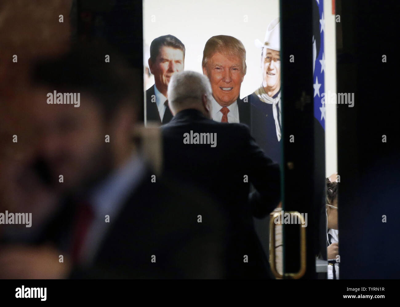 A man enters a room decorated with a Ronald Regan, Donald Trump and John Wayne cardboard cutout / posters in Trump Tower on January 11, 2017 in New York City. U.S. President Elect Donald Trump is still holding meetings upstairs at Trump Tower as he continues to fill in key positions in his new administration.      Photo by John Angelillo/UPI Stock Photo