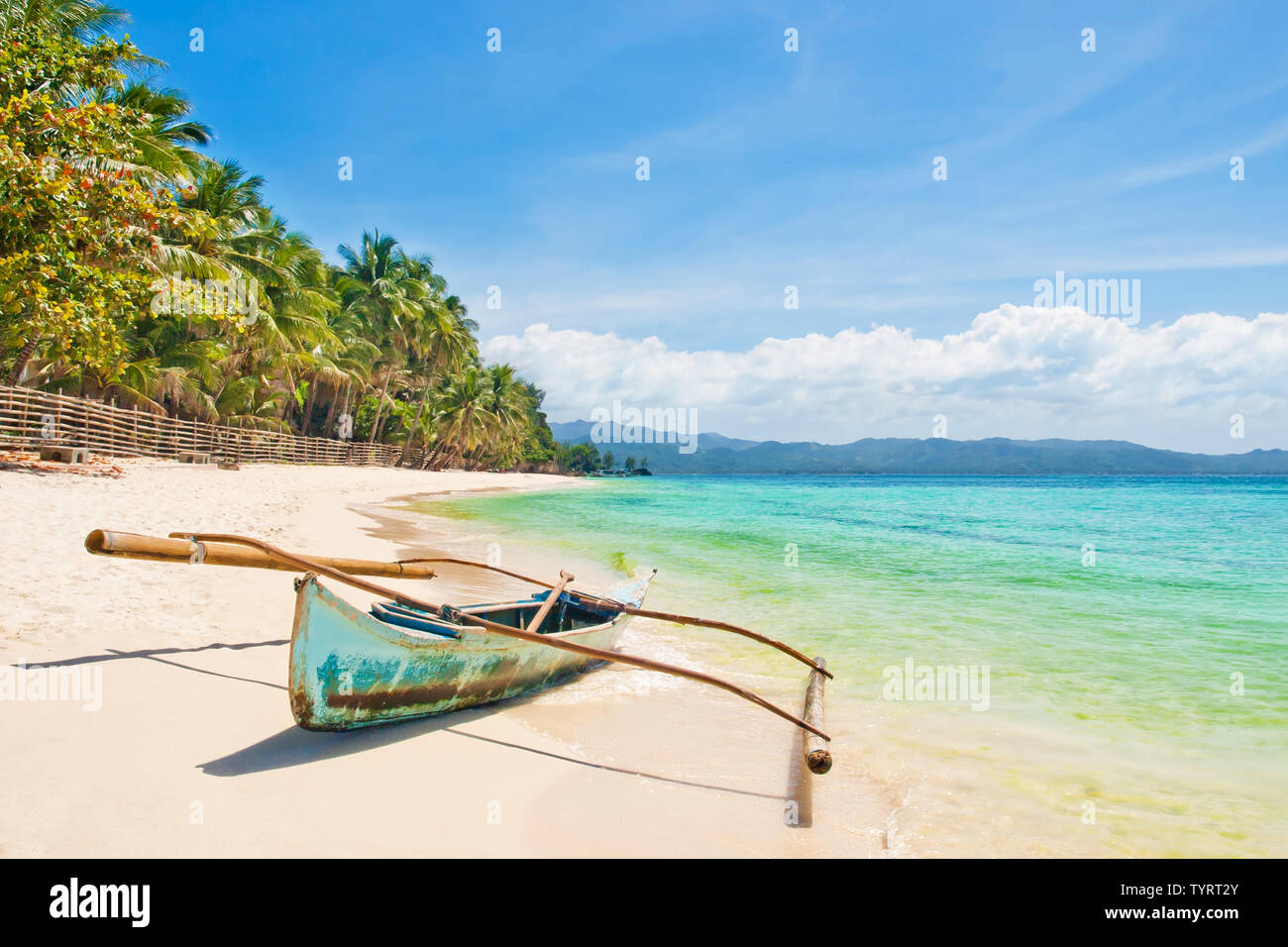 old traditional outrigger fishing boat on white sand beach with palm trees on sunny summer day, Boracay island, the Philippines Stock Photo