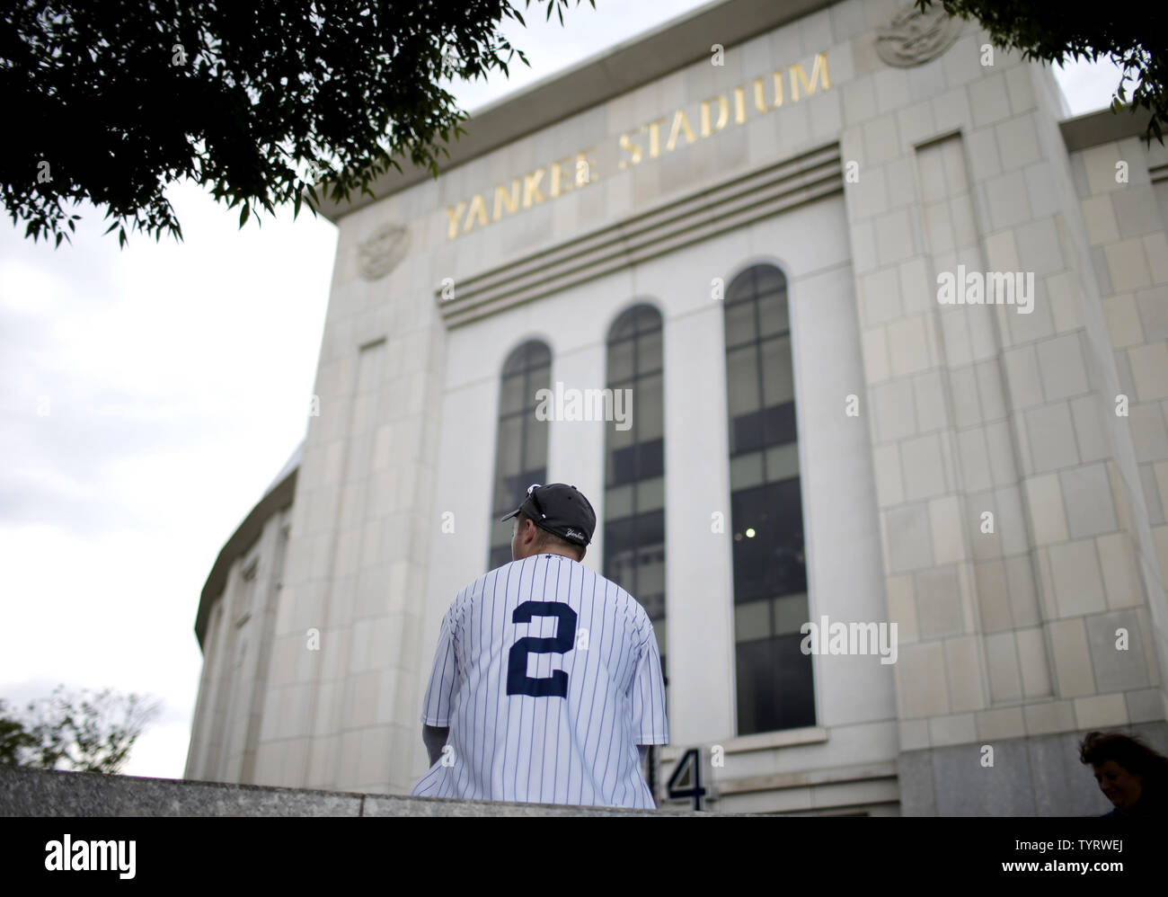 A fan wearing a Yankee Jersey with Derek Jeter's number 2 on it sits outside before the Houston Astros play the New York Yankees at Yankee Stadium in New York City on May 14, 2017. The New York Yankees former shortstop will have his No. 2 retired and will also be honored with a plaque in Monument Park.     Photo by John Angelillo/UPI Stock Photo