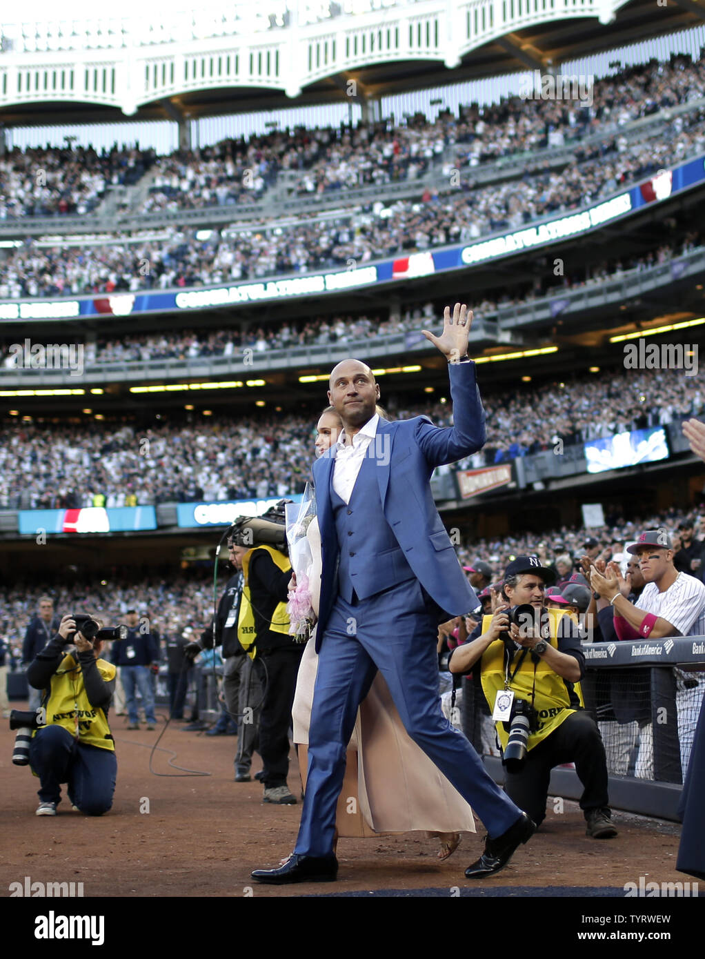 Derek Jeter steps on the field with Hannah Jeter for a ceremony retiring his number before the Houston Astros play the New York Yankees at Yankee Stadium in New York City on May 14, 2017. The New York Yankees former shortstop had his No. 2 retired and was also honored with a plaque in Monument Park.     Photo by John Angelillo/UPI Stock Photo