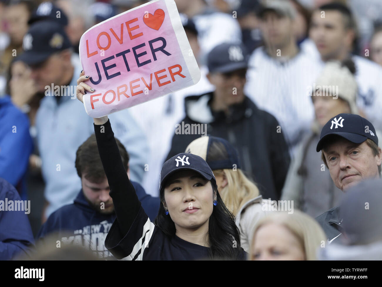 Fans hold up signs and wear shirts honoring Derek Jeter at a ceremony retiring his number before the Houston Astros play the New York Yankees at Yankee Stadium in New York City on May 14, 2017. The New York Yankees former shortstop had his No. 2 retired and was also honored with a plaque in Monument Park.     Photo by John Angelillo/UPI Stock Photo