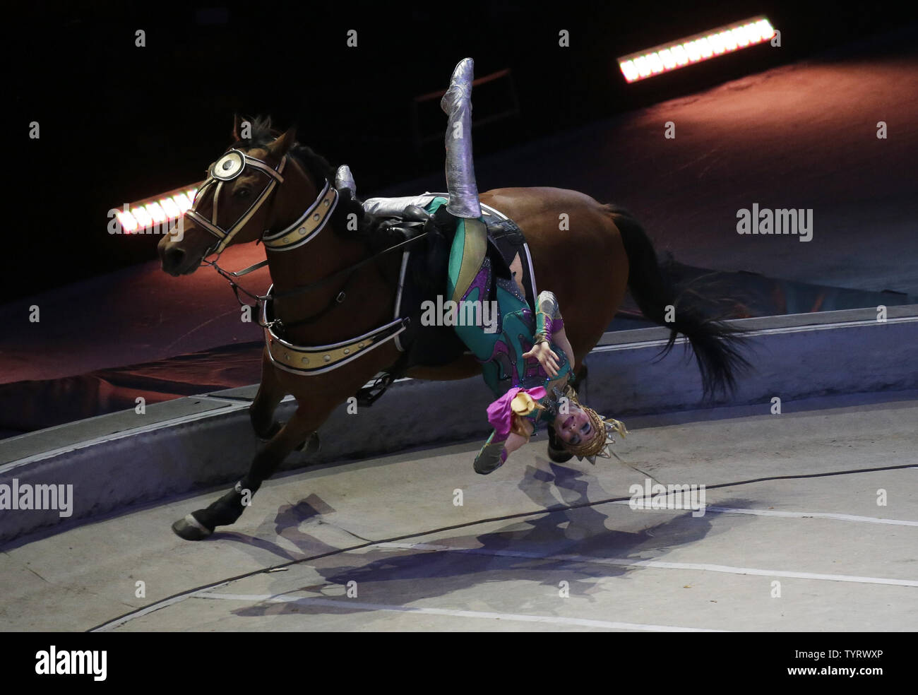 A circus performer trick rides a horse on the final day of performances