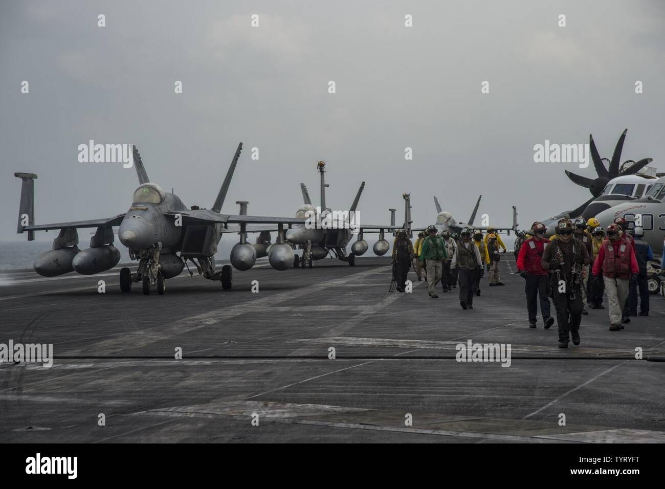 GULF (Nov. 24, 2016) Sailors and aircraft maneuver across the flight deck of the aircraft carrier USS Dwight D. Eisenhower (CVN 69) (Ike). Ike and its Carrier Strike Group are deployed in support of Operation Inherent Resolve, maritime security operations and theater security cooperation efforts in the U.S. 5th Fleet area of operations. Stock Photo