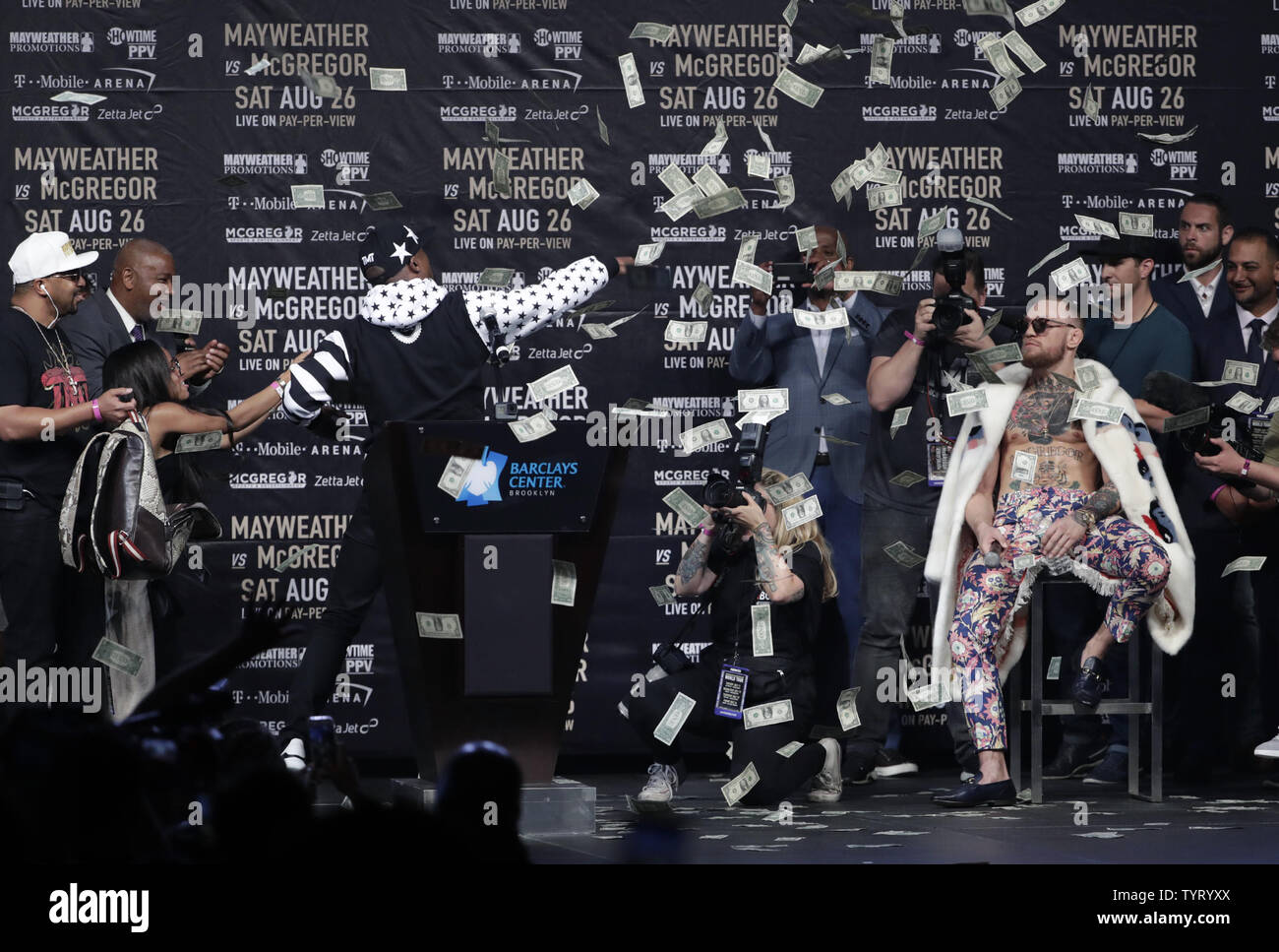 Fighter Floyd Mayweather Jr. (L) throws money at fighter Conor McGregor on  stage as they exchange words at a press tour news conference at Barclays  Center on July 13, 2017 in New