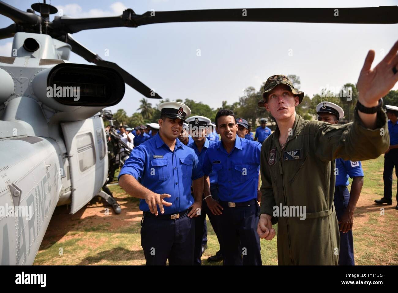 SRI LANKA  (Nov. 24, 2016) Sgt. John Petersen, from the 11th Marine Expeditionary Unit (MEU) attached to the amphibious transport dock ship USS Somerset (LPD 25),  explains the features of a UH-1Y Venom helicopter during an exchange with the Sri Lankan Navy Somerset and embarked 11th Marine Expeditionary Unit are conducting the exchange with Sri Lankan forces in order to enhance tactical skill sets and disaster relief capabilities while strengthening the overall relationship between the two forces. Stock Photo